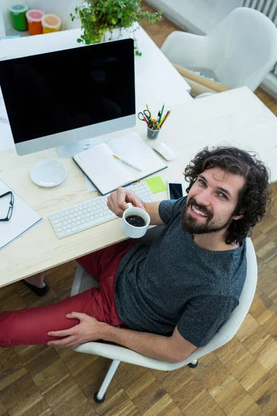 Företagsledare med kaffe vid sitt skrivbord — Stockfoto