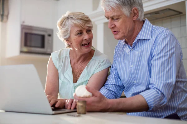 Äldre par kontrollera medicin på laptop — Stockfoto