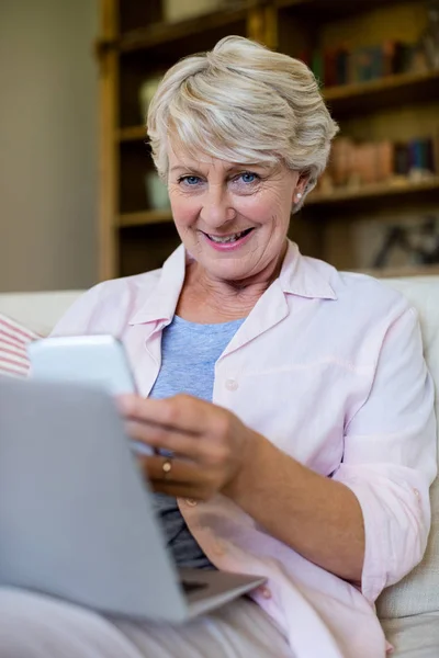 Senior mulher usando telefone na sala de estar — Fotografia de Stock