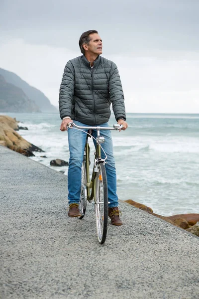 Вдумчивый человек, стоящий на велосипеде — стоковое фото