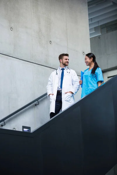 Médico y enfermera caminando por las escaleras y hablando —  Fotos de Stock