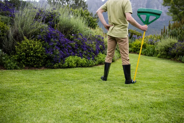 Hombre mayor de pie con herramienta de jardín — Foto de Stock