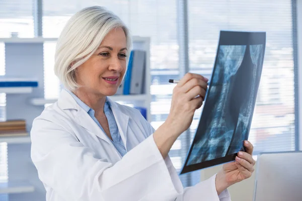 Female doctor examining x-ray report — Stock Photo, Image