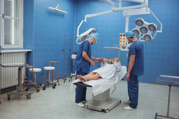 Chirurgen interagieren mit Patienten während der Operation — Stockfoto
