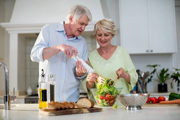 Äldre par förbereder grönsakssallad — Stockfoto