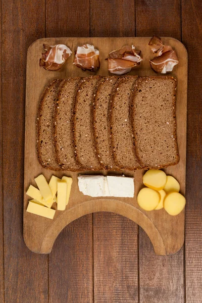 Kromki ciemnego chleba, mięsa i serów — Zdjęcie stockowe