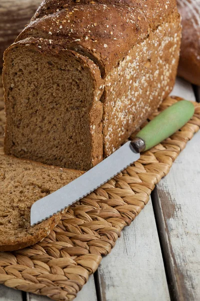 Sliced loaf of bread with knife — Stock Photo, Image