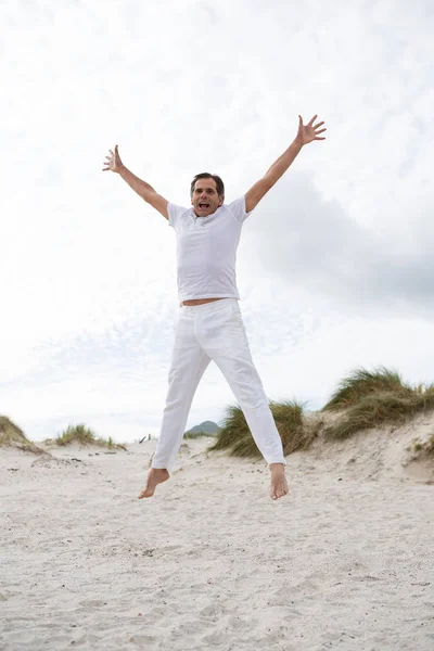 Uomo eccitato che salta sulla spiaggia — Foto Stock