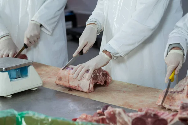 Tukang daging memotong daging di pabrik daging — Stok Foto