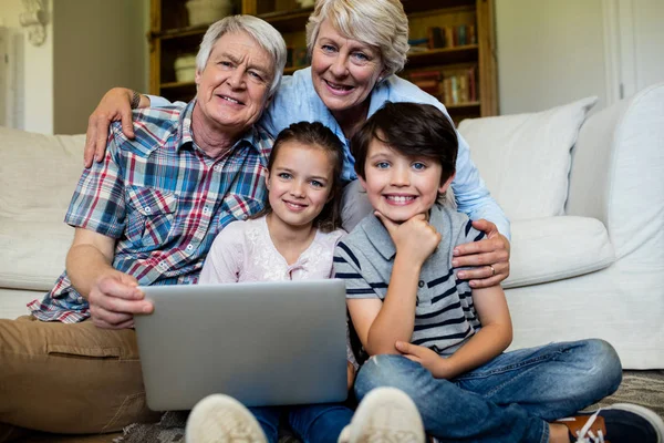 Barnbarn och mor-och farföräldrar med laptop — Stockfoto