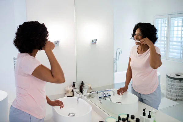 Mujer cepillándose los dientes en el baño —  Fotos de Stock