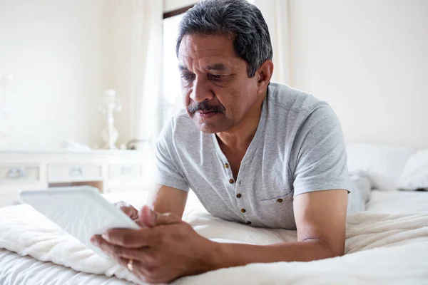 Senior man using tablet on bed — Stock Photo, Image