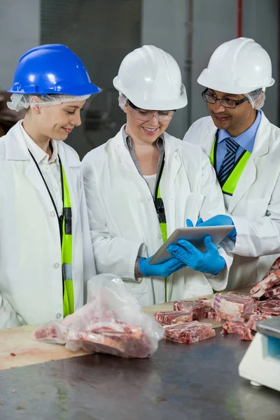 Techniker mit Tablette bei der Untersuchung von Fleisch — Stockfoto