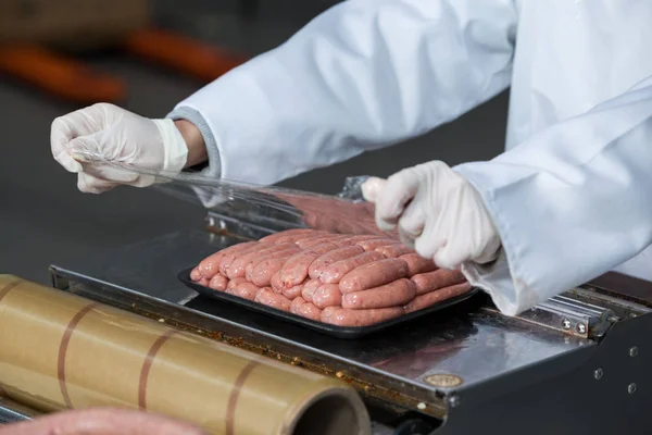 Metzger verpackt Rohwürste — Stockfoto