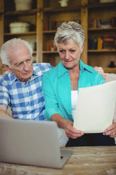 Äldre par Kontrollera räkningar i vardagsrum — Stockfoto