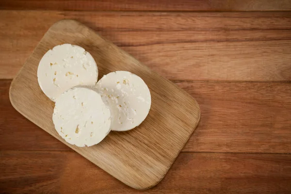 Rebanadas de queso en la tabla de cortar — Foto de Stock