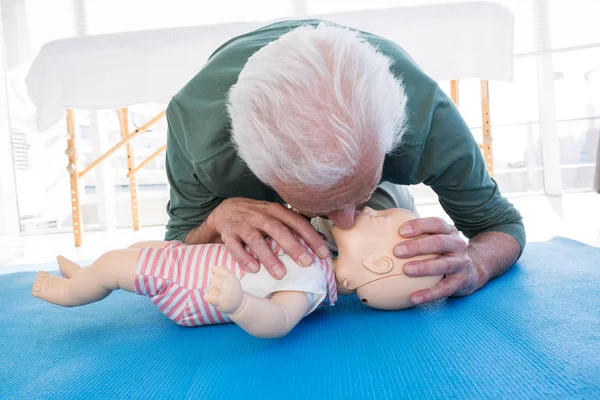 Ambulancier pratiquant la réanimation bouche à bouche sur mannequin — Photo