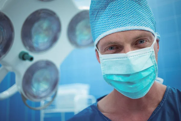 Portrait of male surgeon wearing surgical mask in operation theater — Stock Photo, Image