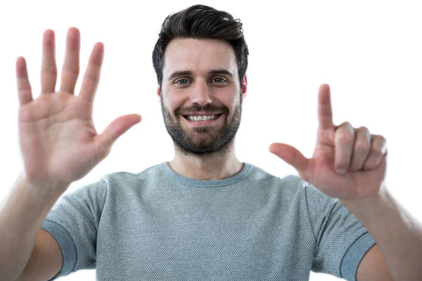 Mann gibt vor, einen unsichtbaren Bildschirm zu berühren — Stockfoto