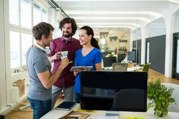 Team of graphic designers discussing over tablet — Stock Photo, Image