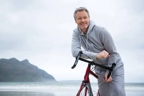 Retrato de homem feliz apoiado na bicicleta — Fotografia de Stock