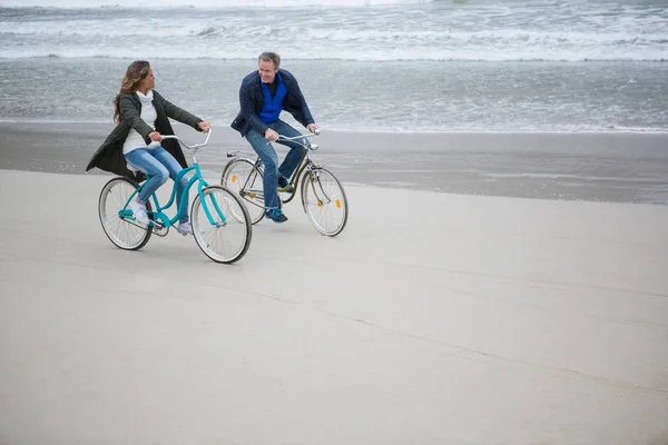 海滩上的情侣骑自行车 — 图库照片