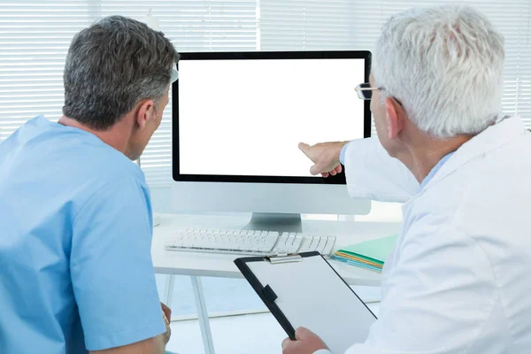 Cirujano y médico discutiendo sobre computadora personal — Foto de Stock