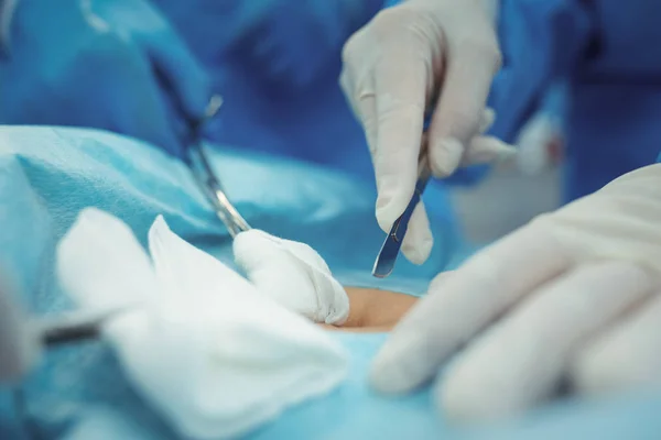 Cirurgião com bisturi realizando operação no teatro de operação — Fotografia de Stock