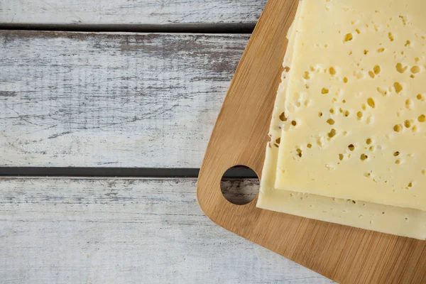 Rebanadas de queso en la tabla de cortar — Foto de Stock