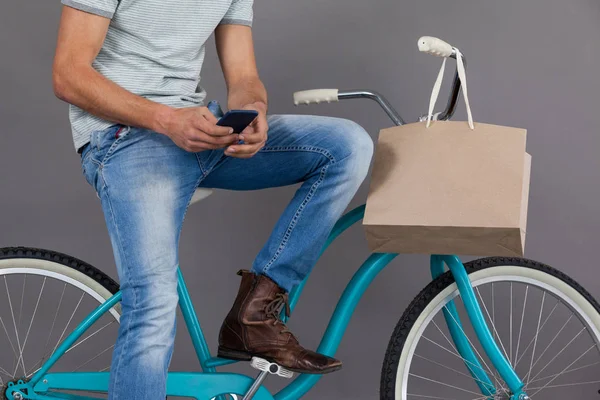 Hombre sentado en una bicicleta y usando el teléfono —  Fotos de Stock