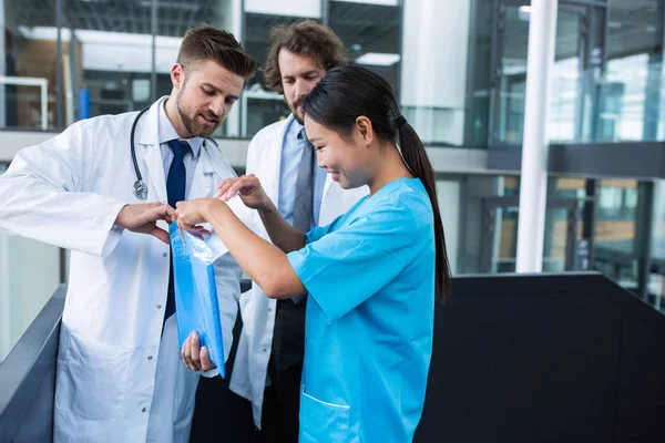 Médico y enfermera abriendo una carpeta de archivos — Foto de Stock