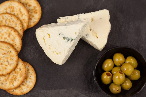 Galletas crujientes, queso y tazón de aceitunas verdes —  Fotos de Stock