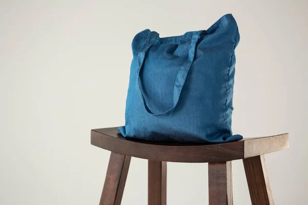 Синя сумка на дерев'яному табуреті — стокове фото