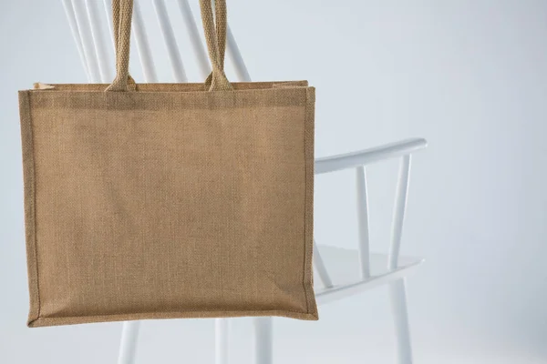 Sac en jute suspendu sur une chaise blanche — Photo