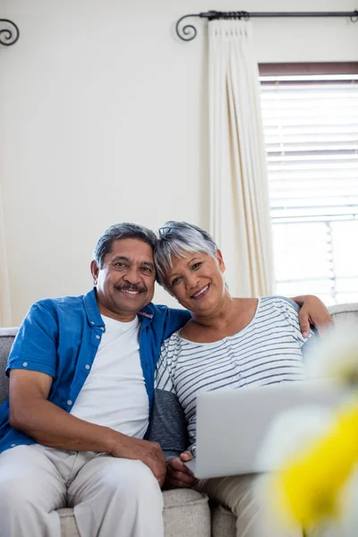 Äldre par med laptop i vardagsrum — Stockfoto