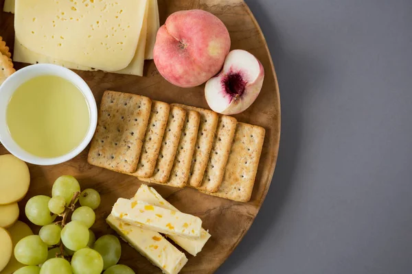 Queso con uvas, melocotón y galletas saladas —  Fotos de Stock