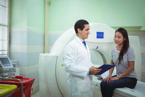 Médico e paciente discutindo sobre prancheta — Fotografia de Stock