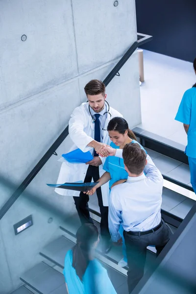 Läkare och sjuksköterska diskutera över en rapport medan klättra nedför trappor — Stockfoto