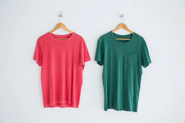 Camisetas de color rosa y verde colgando de la percha — Foto de Stock