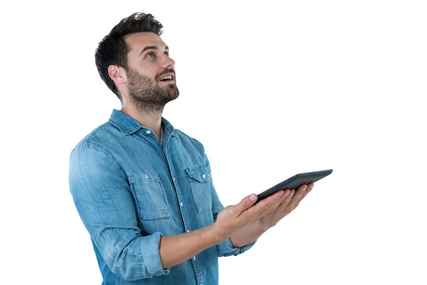 Bonito homem olhando para cima enquanto segurando tablet — Fotografia de Stock