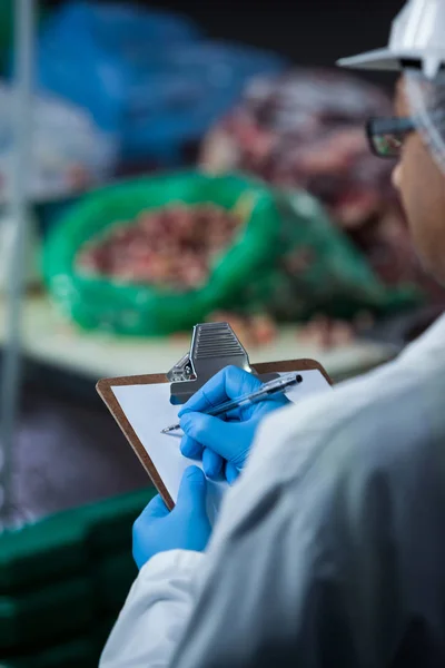 Techniker pflegen Aufzeichnungen auf Klemmbrett — Stockfoto