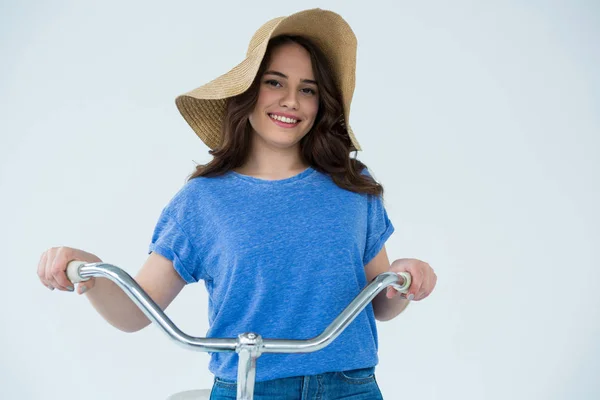 Woman in blue top and hat holding bicycle — Stock Photo, Image