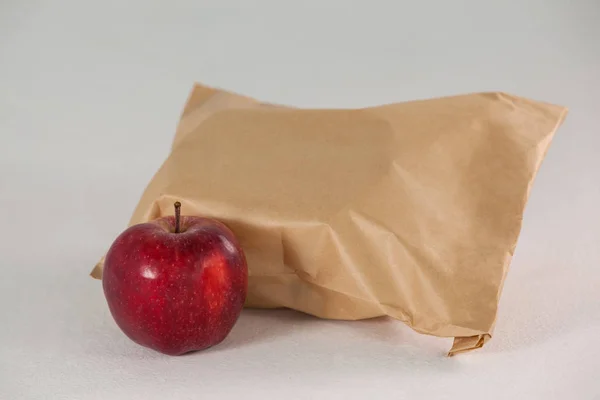 Brown paper lunch bag with red apple — Stock Photo, Image