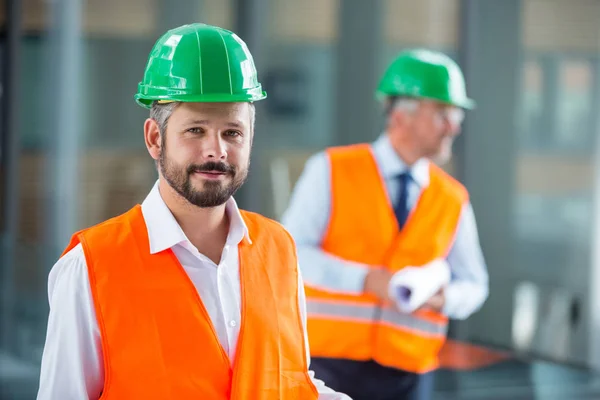 Arkitekt i hård hatt stående i office korridor — Stockfoto