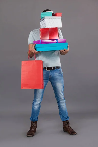 Hombre sosteniendo pila de cajas de regalo y bolsa de compras — Foto de Stock