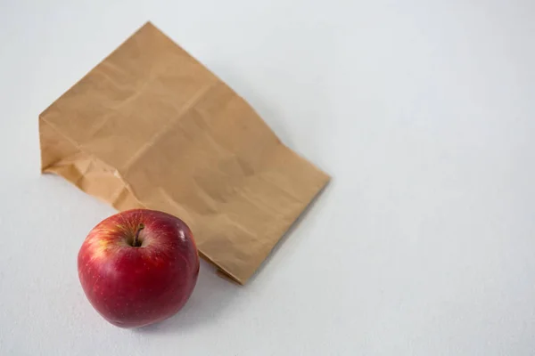 Бумажный пакет с красным яблоком — стоковое фото