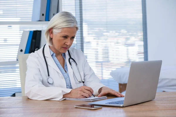 Médica trabalhando em sua mesa — Fotografia de Stock