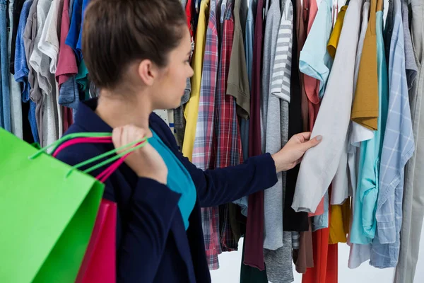 Donna che sceglie i vestiti in negozio — Foto Stock