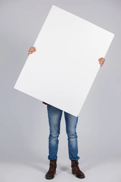 Homem segurando um cartaz em branco na frente da cara — Fotografia de Stock