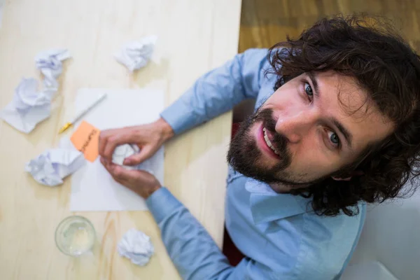 Designer gráfico esmigalhando papel em sua mesa — Fotografia de Stock